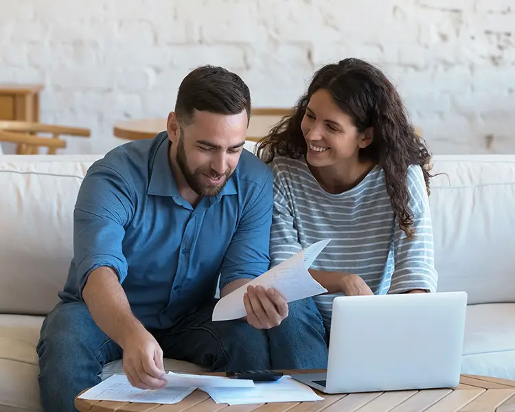 Un couple devant des papiers et un ordinateur